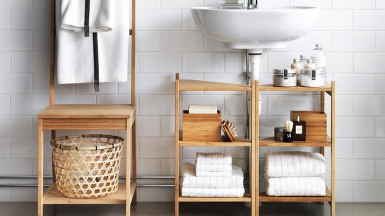 Two bamboo RÅGRUND shelves sit under a white bathroom sink