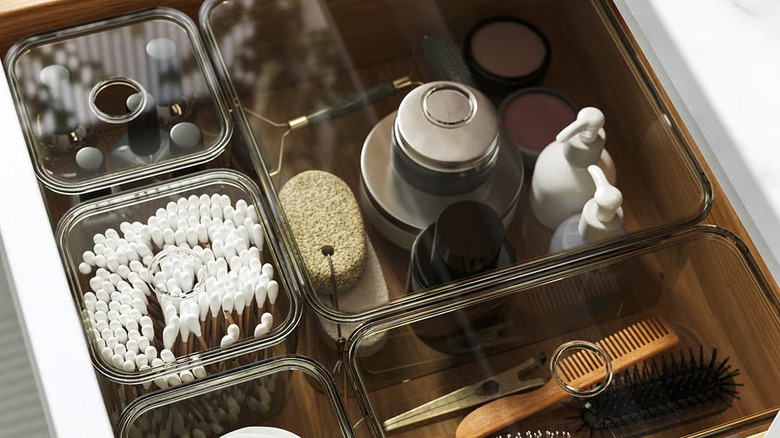 A bathroom drawer is fitted with VISSLAÅN Boxes full of toiletry items