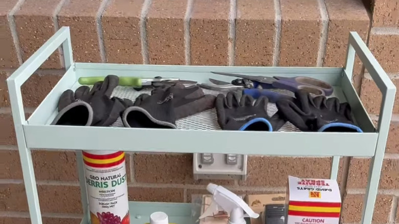 Two levels of the NISSAFORS utility cart with gardening supplies on them.