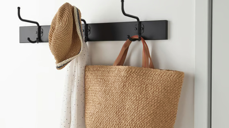 Set of black coat hooks on an interior wall.