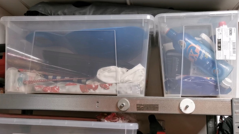Basic clear plastic storage boxes on a garage shelf.