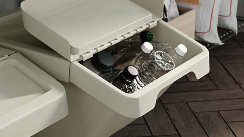 SORTERA recycling bin that's full of plastic bottles.