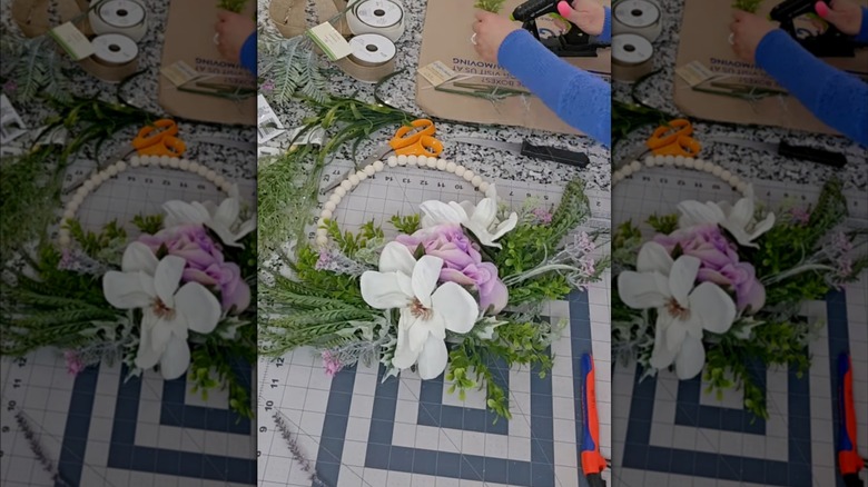 Woman making a spring floral wreath with Dollar Tree supplies.