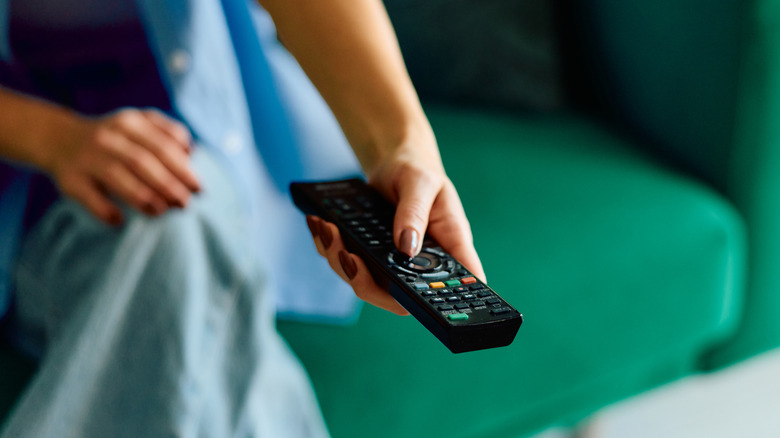 Woman using TV remote