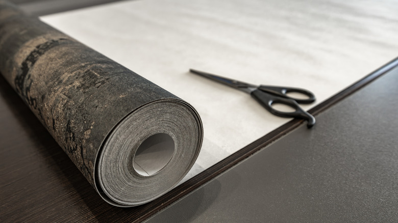 Roll of wallpaper and scissors