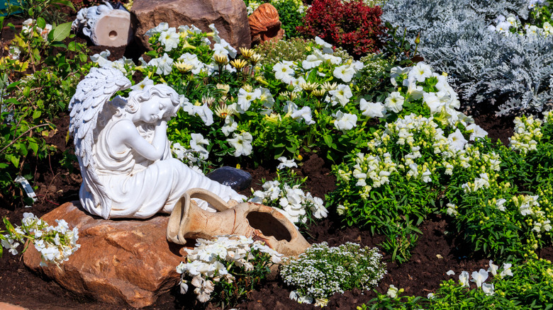 Angel garden statue surrounded by petunias