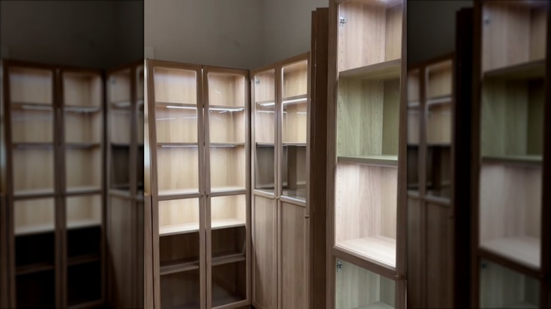 wood grain IKEA BILLY cabinets with glass OXBERG doors create a high-end pantry