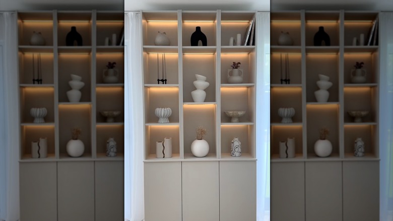 IKEA BILLY bookshelves with custom lighting routed into the bottom of each shelf to create a custom display cabinet