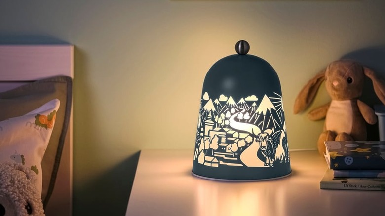 A unique bell-shaped lamp sits on a child's bedside table
