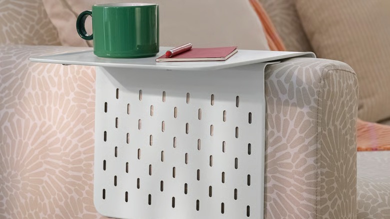 A white KRAMPHULT armrest tray over the armrest of a couch.