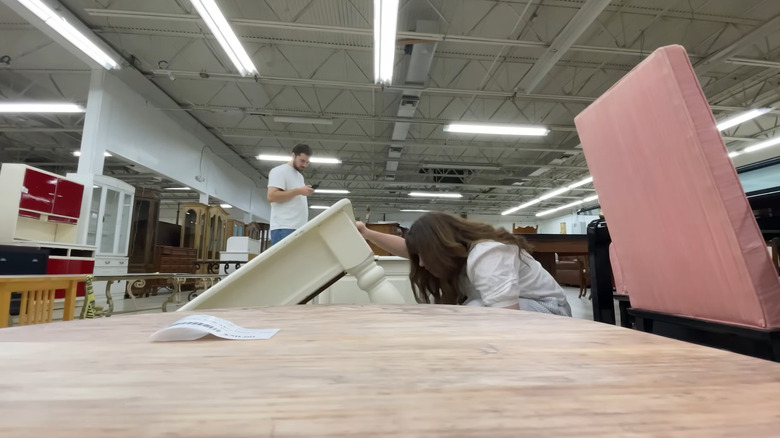 People looking in the furniture section at a thrift store