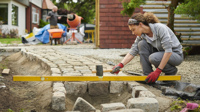 homeowner installing a cobble path