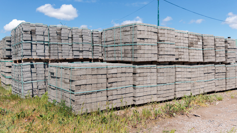 Concrete pavers are stacked on wooden pallets,