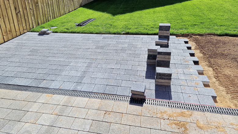 A stone paver patio in the process of being installed in a garden