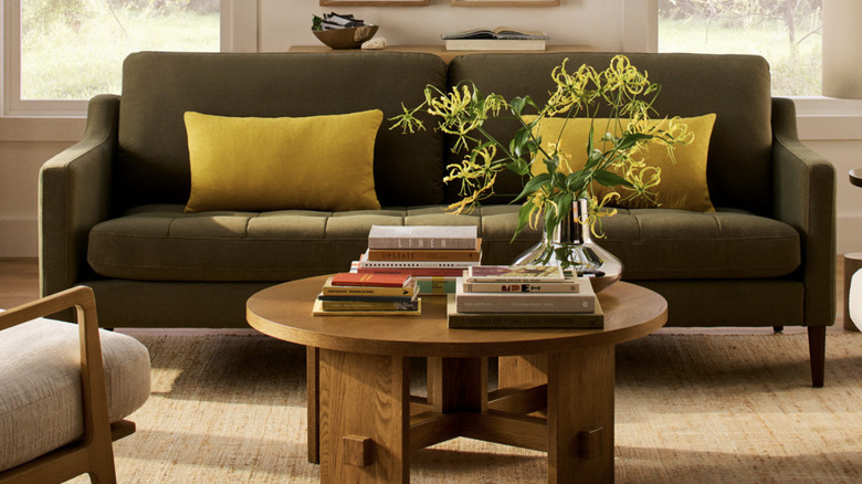 Contemporary-style green sofa with yellow cushions on it