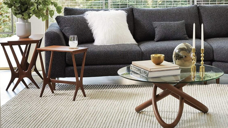 Modern coffee table and wooden end tables next to a gray sofa