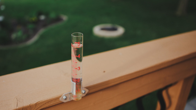 rain gauge attached to railing of deck