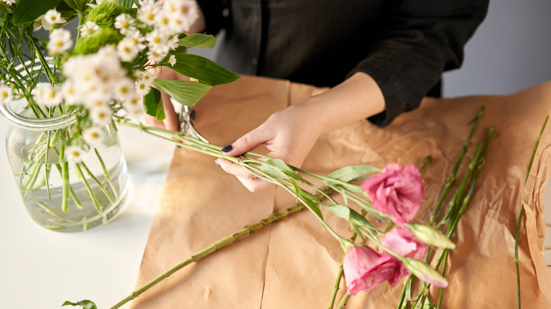 woman put cut flowers in a vase