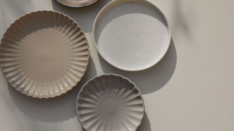 collection of neutral colored plates on a beige table