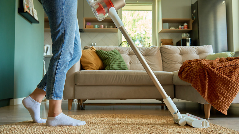 a woman cleaning a carpet with a cleaner