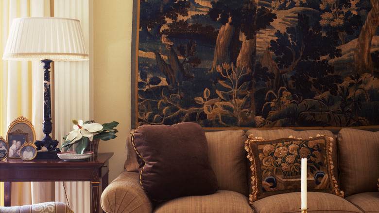 Brown couch with traditional dark-colored tapestry in living room