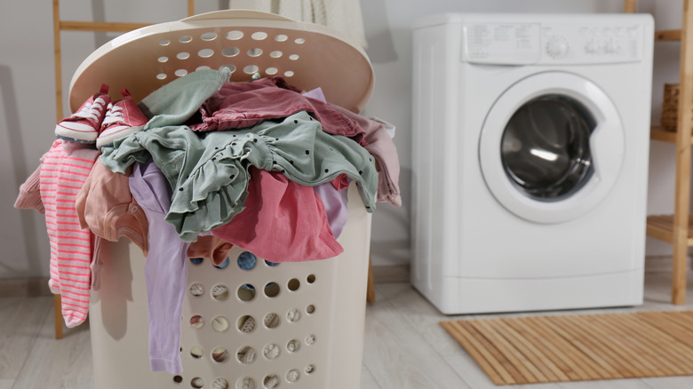 Full laundry basket next to washing machine