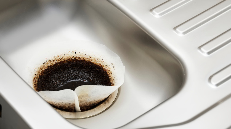 A coffee filter filled with coffee set gently inside the drain.