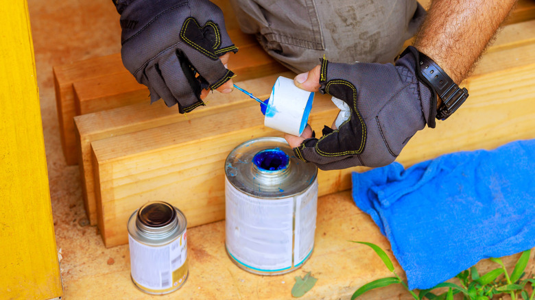A plumber applying glue to PVC pipe