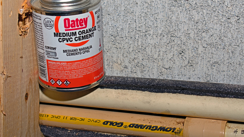 CPVC pipes and can of Oatey medium orange CPVC cement cement