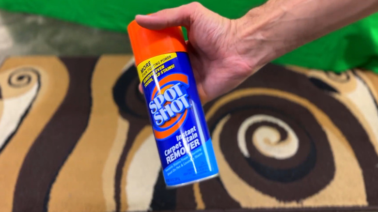 A man holding a can of Spot Shot