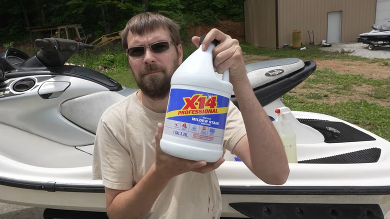 man holding up a bottle of X-14 mildew stain remover