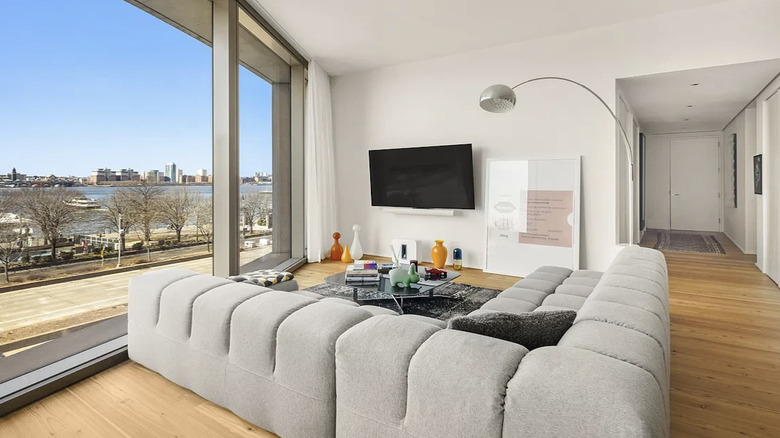 A minimalist, bright living room of an apartment with an Arco light