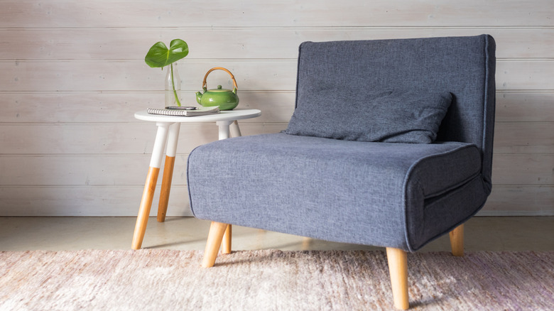 grey convertible chair in net to white side table with teapot