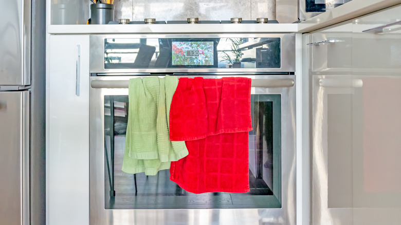Green and red kitchen towels on oven door handle