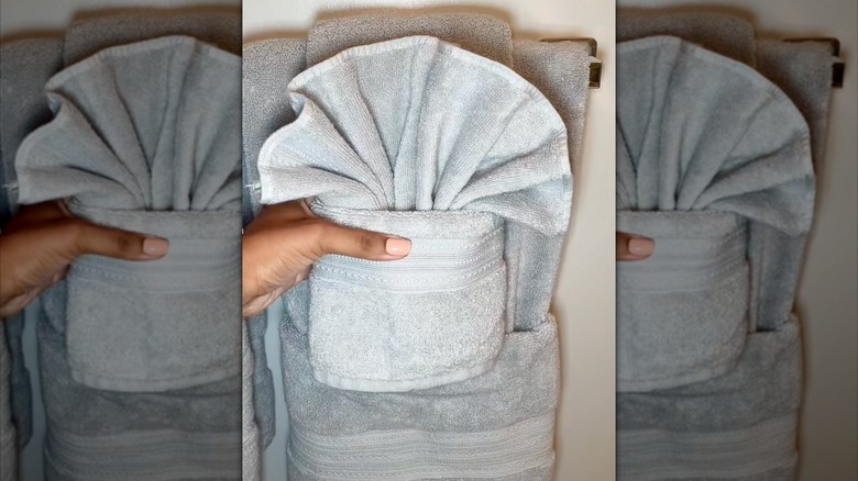 Hand grabbing fancy folded towel