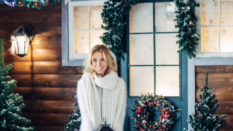 Woman smiling as she gets outdoor Christmas decorations ready