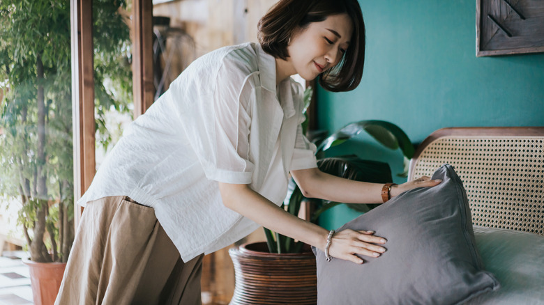 woman placing pillow on bed
