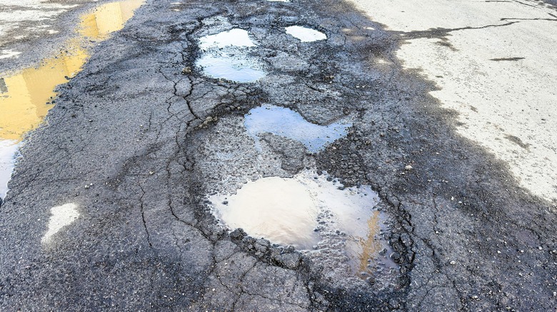 Damaged asphalt driveway with cracks and potholes