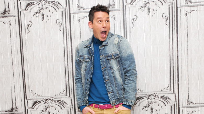 a picture of david bromstad with his mouth open wide in surprise in front of a paneled white wall