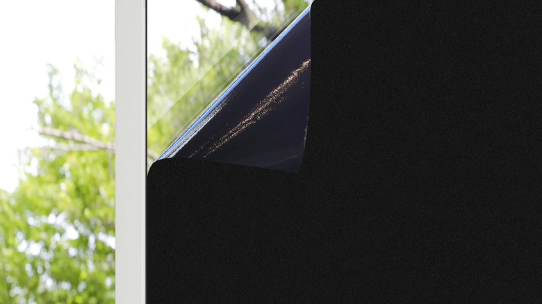 Ebern Designs Blackout Window Decal stuck on window glass with folded-back corner