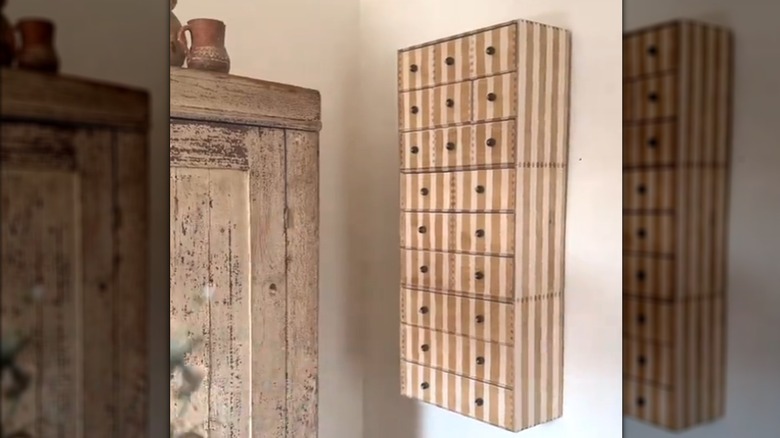 Finished IKEA hanging wood cabinet DIY with stripes and bead handles beside rustic wood cabinet