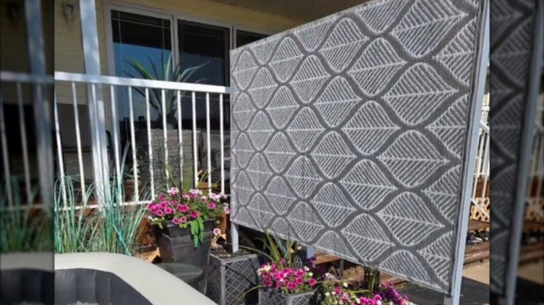 Homemade outdoor privacy screen with planter boxes bordering backyard hot tub