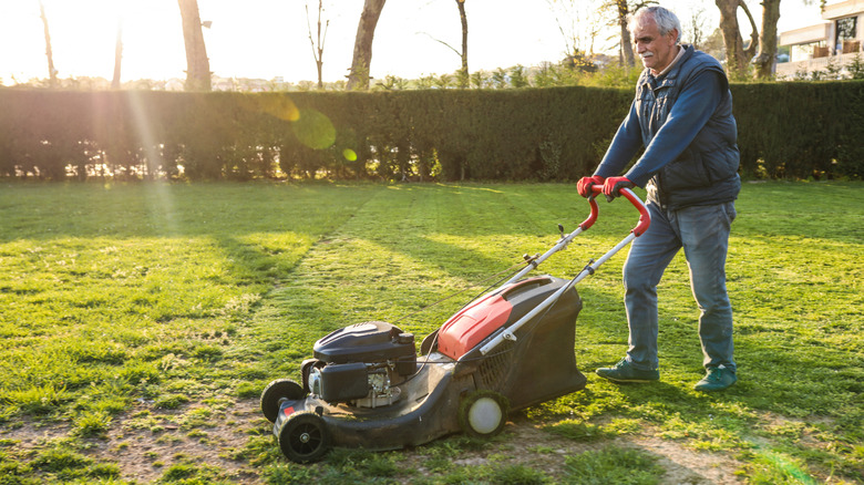 Man mowing a lawn with uneven spots