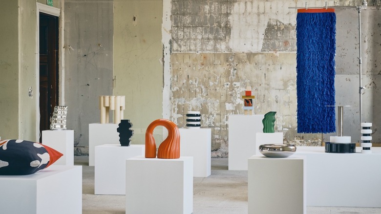 All of the vibrant pieces of the IKEA KONSTRUNDA art collection in a white industrial warehouse