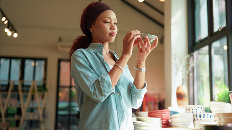 A young woman examines bowls in a store