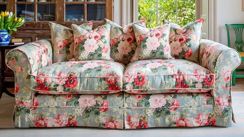 A pink and blue chintz sofa in a living room
