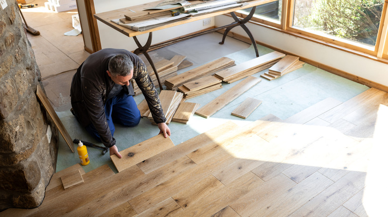 Person installing wooden flooring