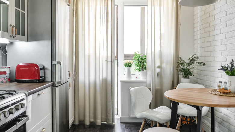 Cramped kitchen with Scandinavian-style furniture and cluttered counters