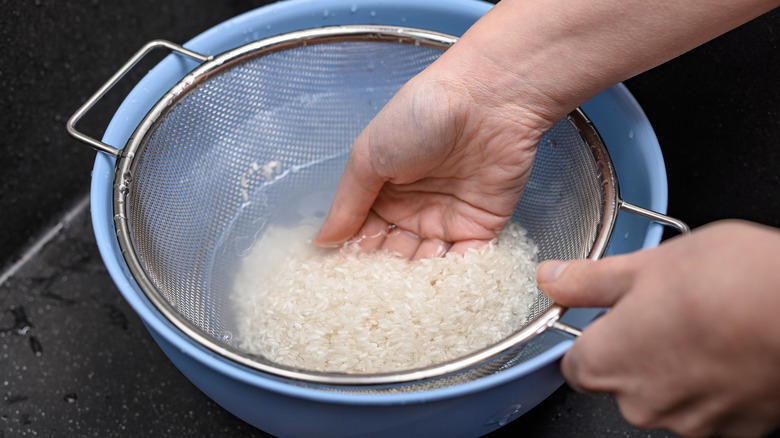 Person in kitchen rinsing rice