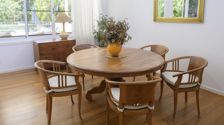 dining room with matching medium-toned wood round table and curved barrel back chairs